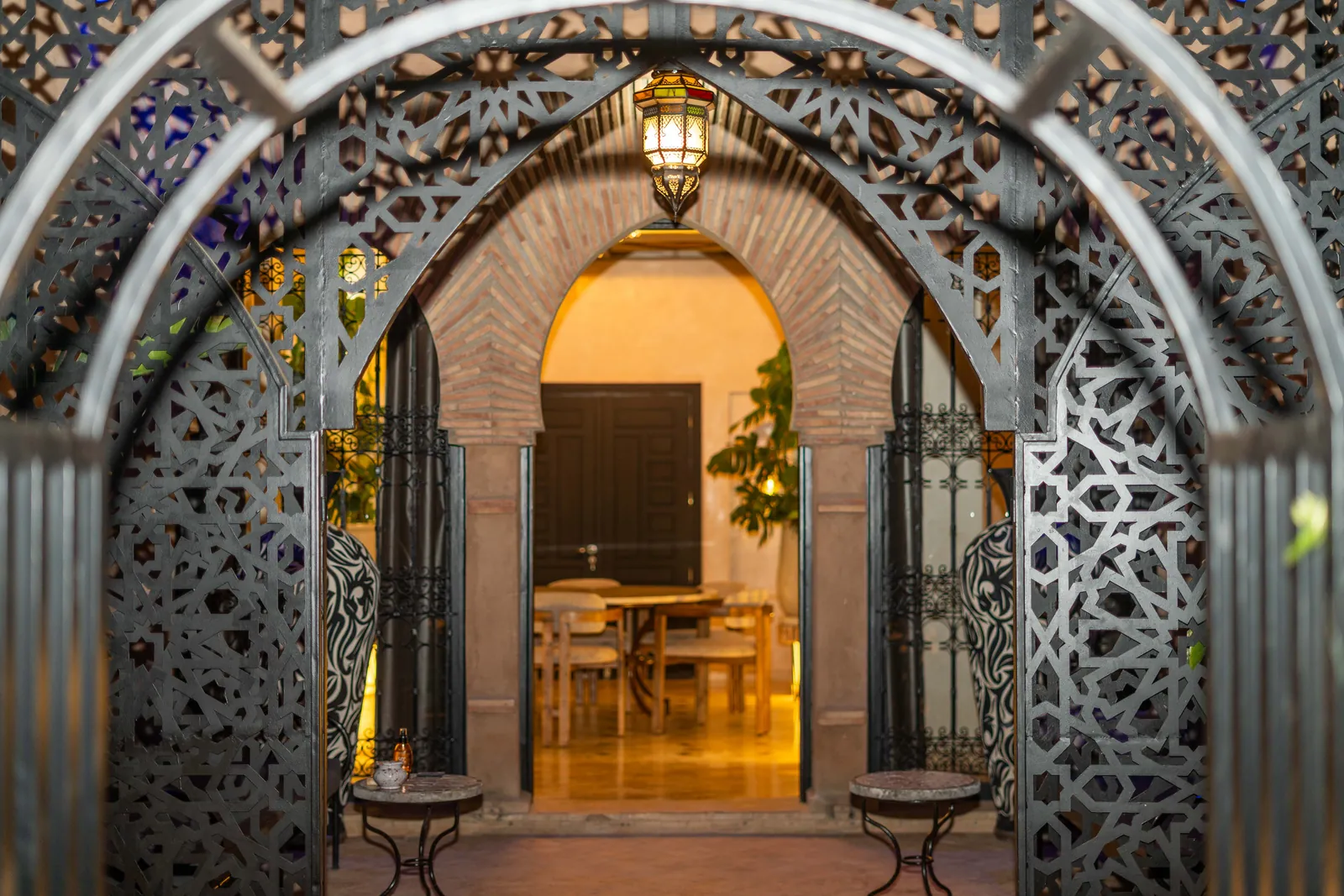 Riad entrance framed by zellige tiles and a carved arch